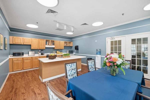 Bright kitchen area with wooden cabinetry and dining table.