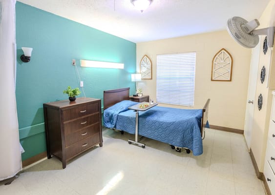 A well-furnished resident room with a bed and decor