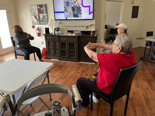 Residents participating in a seated exercise session