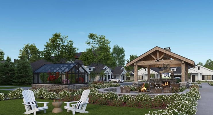 A scenic outdoor lounge with seating, a fire pit, and a greenhouse.