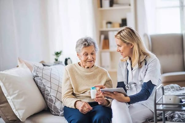 A caregiver and a senior resident interacting in a cozy living space