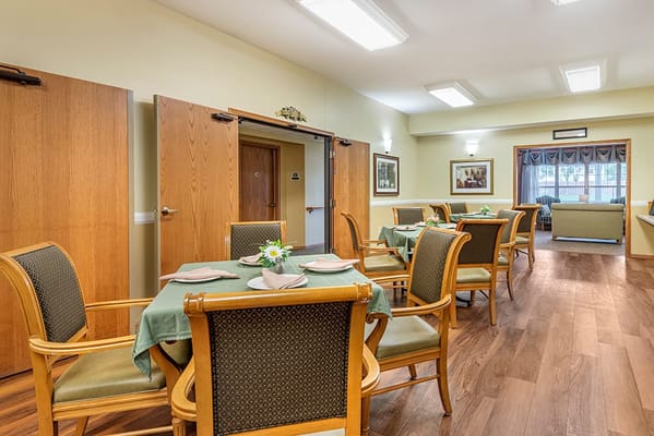Bright dining area with tables set for residents