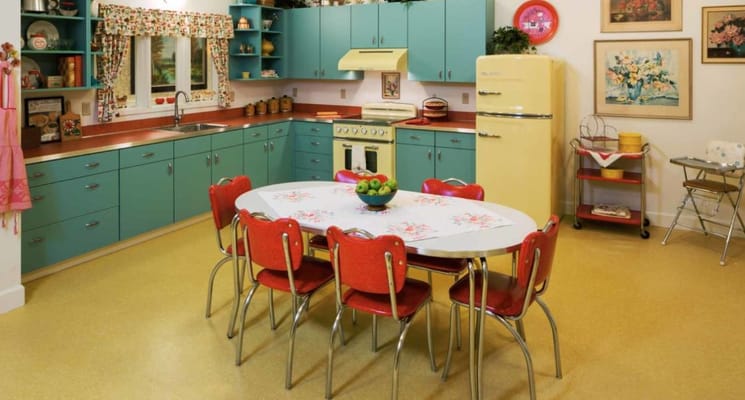 Bright kitchen with a round table and red chairs
