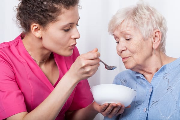 Nurse feeding a resident in a cozy setting