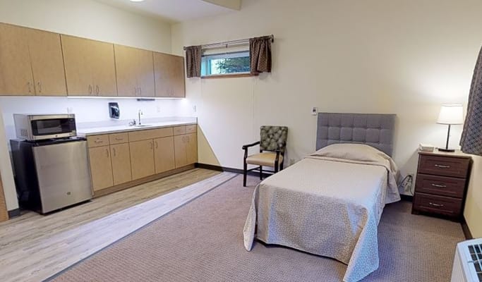 Cozy resident room with kitchenette and bed