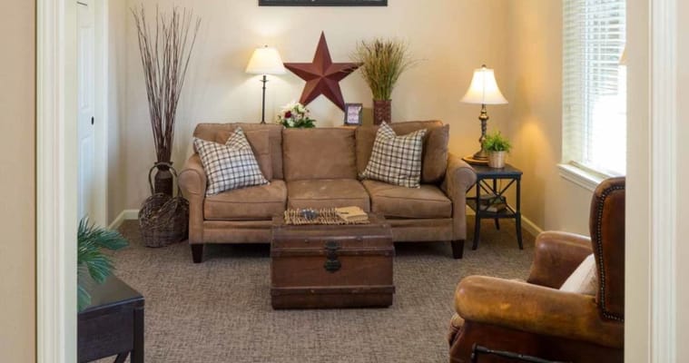 A cozy living room with a sofa, decorative pillows, and lamps.
