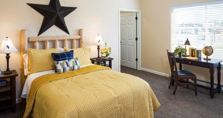 Cozy bedroom with yellow bedspread and desk
