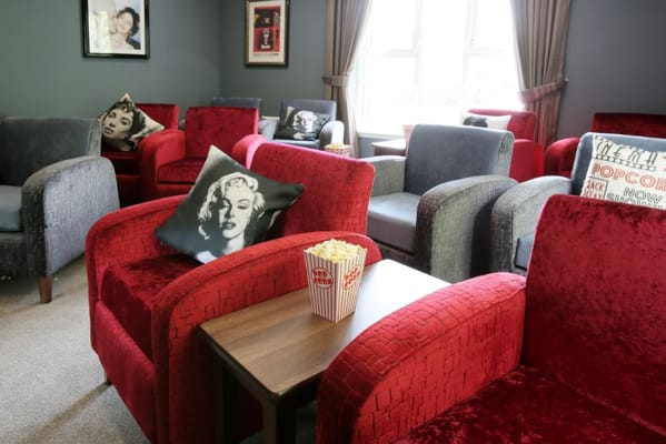 Cozy lounge area with red chairs and popcorn