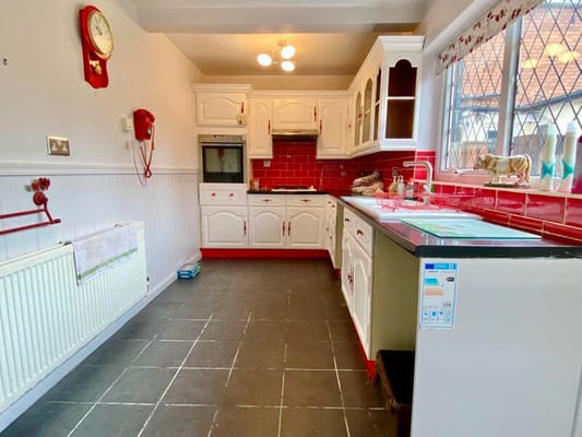 Bright kitchen with red accents and white cabinetry at Lawndale.