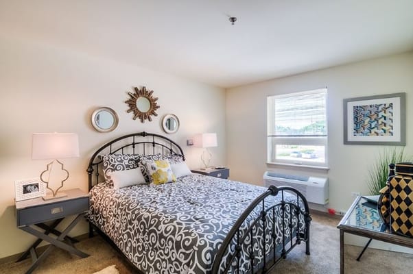 Cozy bedroom featuring a bed, bedside lamps, and decorative accents.