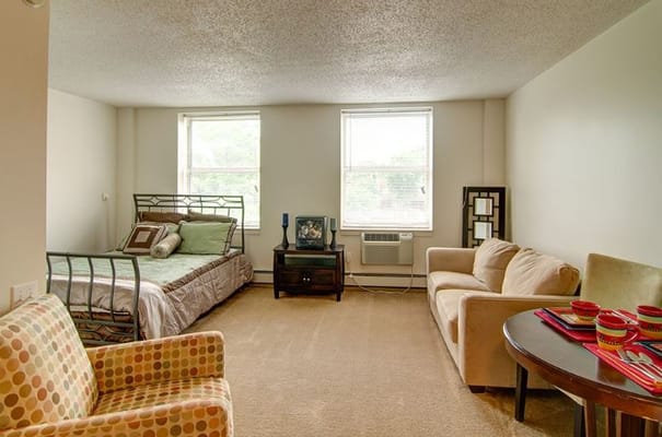 Cozy bedroom with bed, seating area, and natural light
