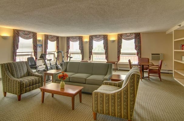 Lounge area with seating and exercise equipment in Senior Suites West Humboldt Park