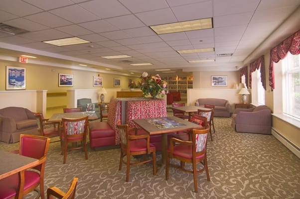 Cozy lounge area with seating and tables in Senior Suites New City