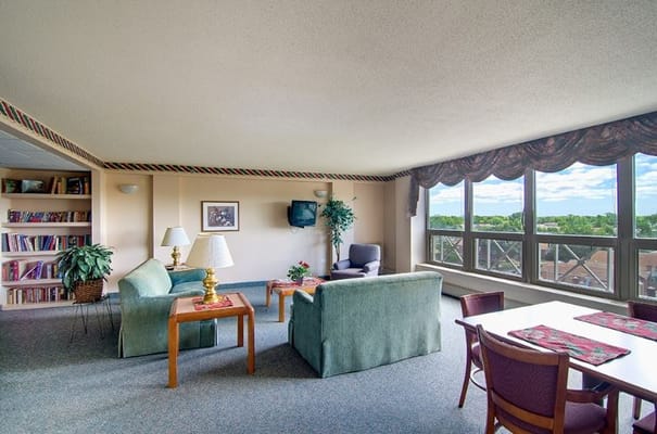 Spacious living area with sofas, a table, and large windows