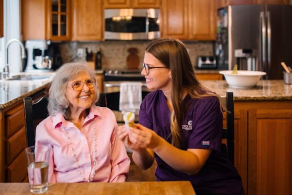 A caregiver engaging with a senior resident in a kitchen