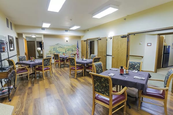 Dining room with tables and chairs set up for residents