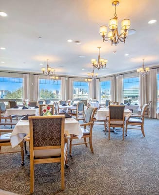 Elegant dining room with large windows and chandeliers