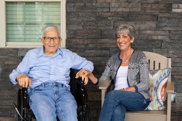 A resident and staff member chatting outdoors