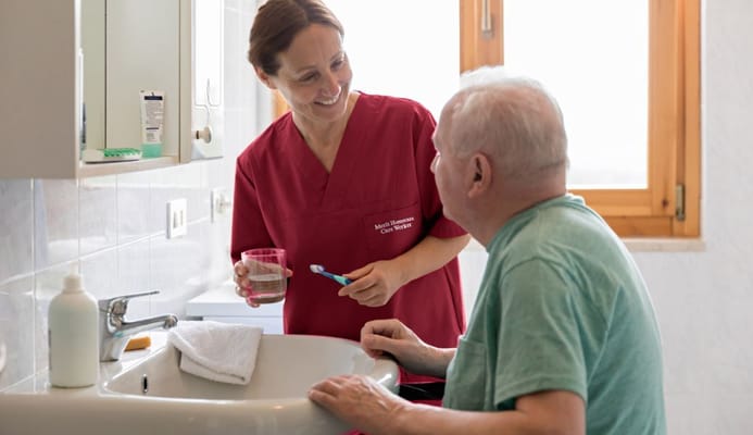 A caregiver assisting a resident in a bathroom