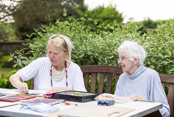 Residents enjoying arts and crafts in a garden setting