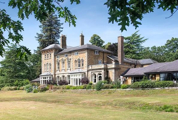 Exterior view of Merlewood Care Home surrounded by greenery