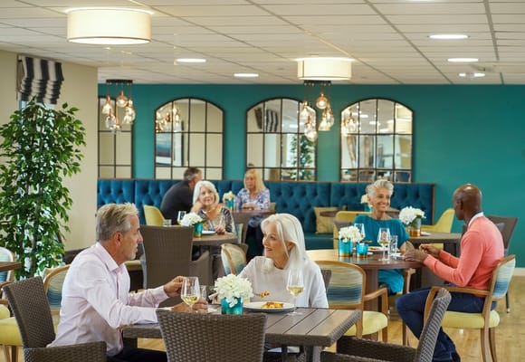 Residents socializing in a bright dining room