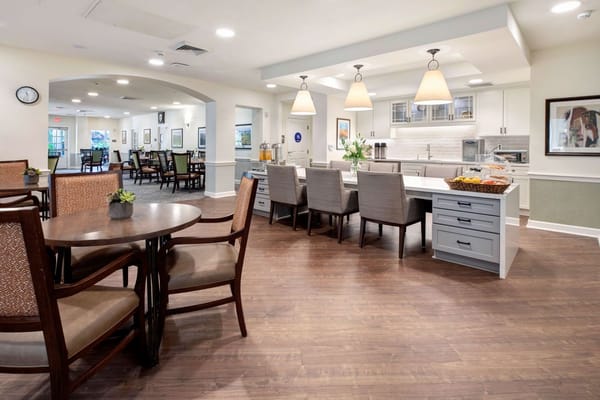 Bright kitchen and dining area with tables and chairs.