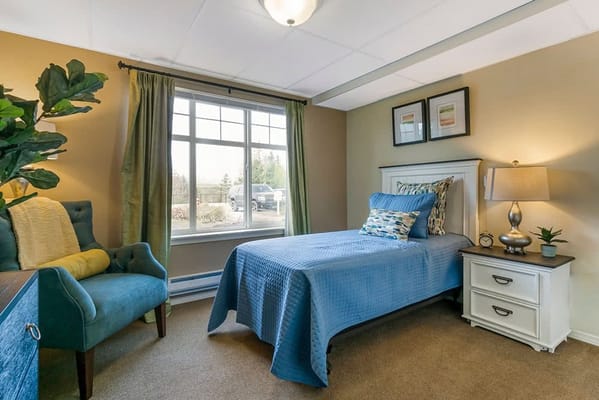 A well-furnished private resident room with blue decor