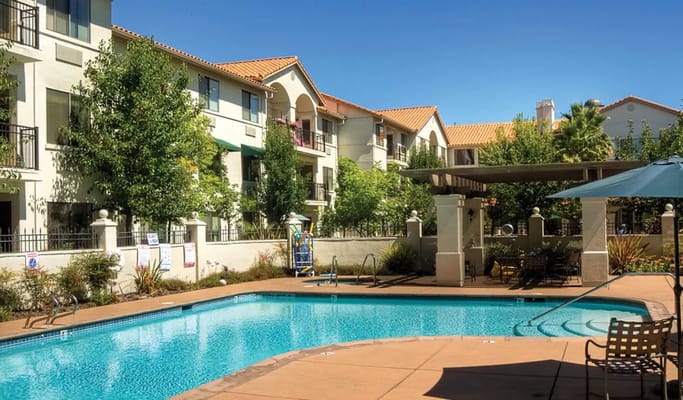 Outdoor pool area with residential building in background