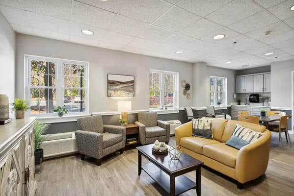 Cozy living room with seating, natural light, and kitchenette