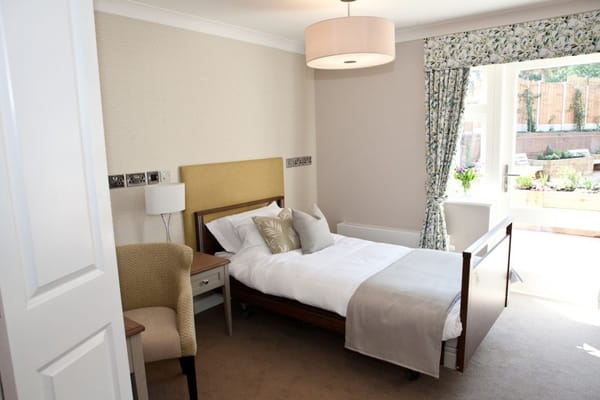 Bright, well-furnished resident room with garden view