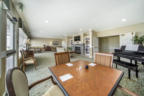 Bright common area with seating and a piano