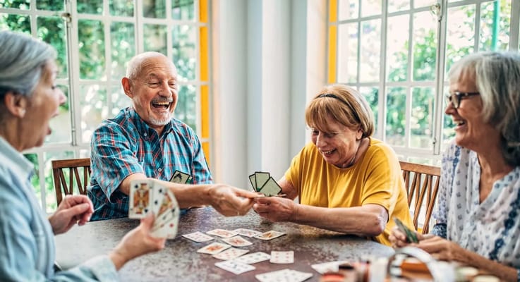 Residents playing cards in a bright common area