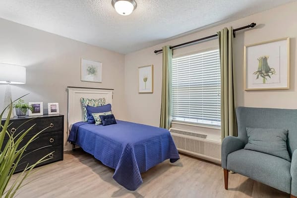 Private resident room with a bed and chair