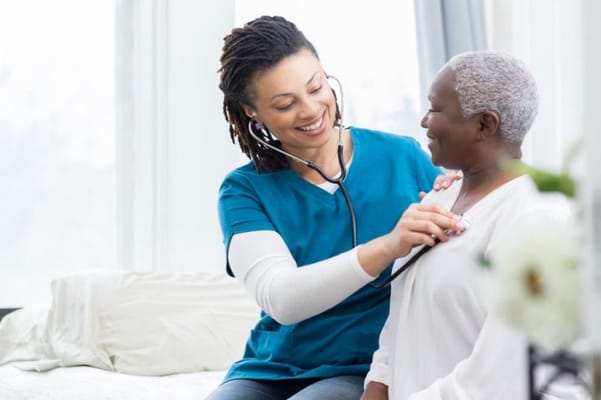 Nurse checking on a senior resident in a bright room