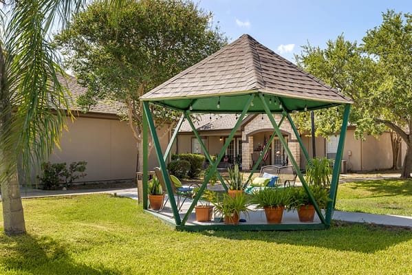 Outdoor gazebo area with seating and plants