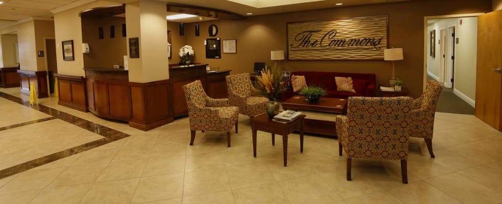 Cozy lobby seating area with patterned chairs and a reception desk.
