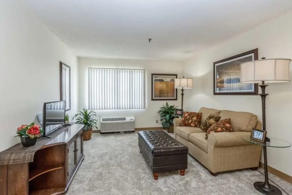 Spacious living room with a couch, TV, and lamp
