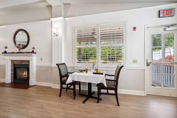 Dining table set for two with a fireplace in the background