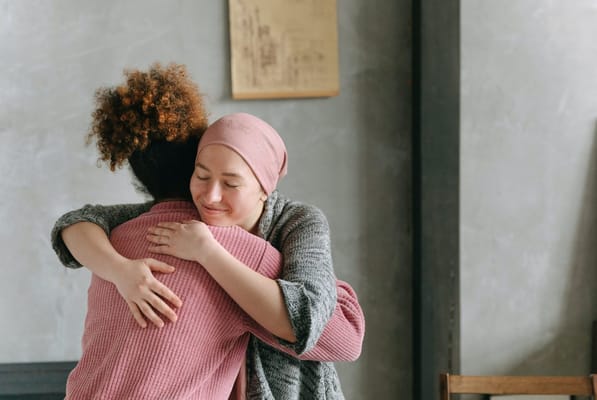 Two women hugging in a cozy interior space