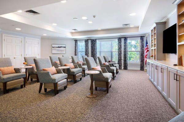 Cozy lounge seating area with gray chairs in a senior living facility