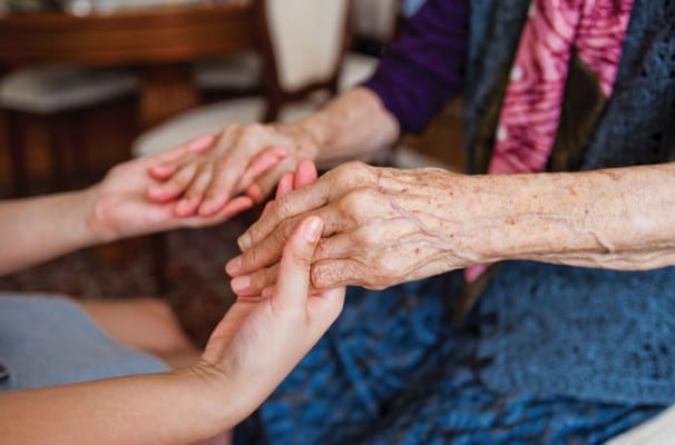 Two hands clasped in a caring gesture