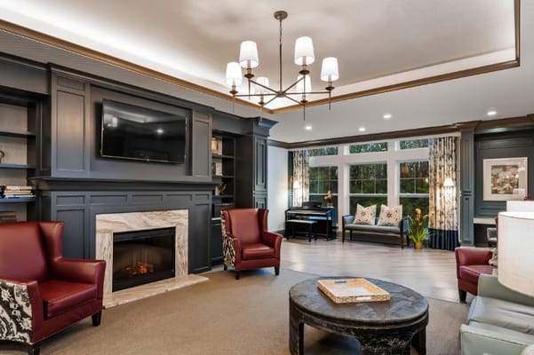 Lounge with comfortable chairs, fireplace, and piano