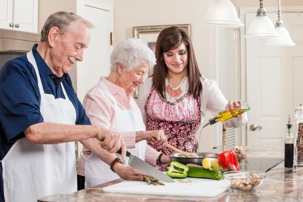 Residents and staff cooking together in a kitchen