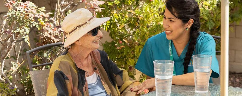 Senior woman chatting with caregiver outdoors