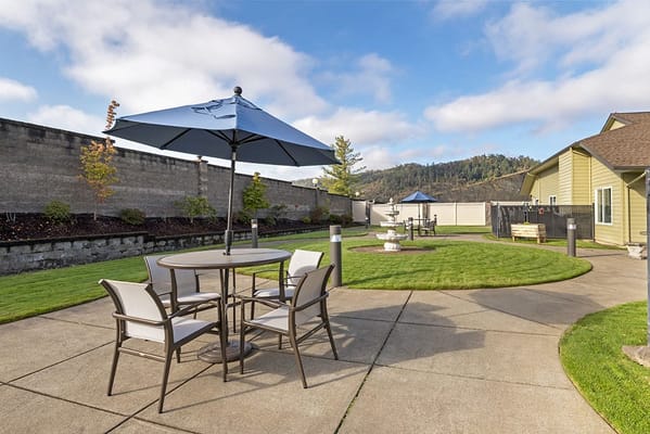 Outdoor seating area with umbrellas and green lawn