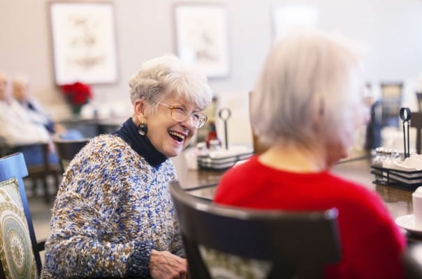 Two seniors enjoying a conversation in the dining room.