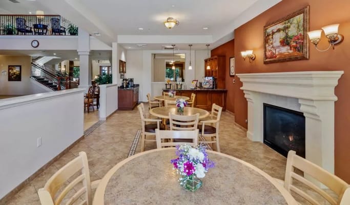 Bright common area with tables and fireplace