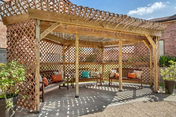 Outdoor shaded seating area with benches and cushions