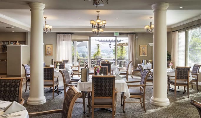 Bright dining room with tables set for residents